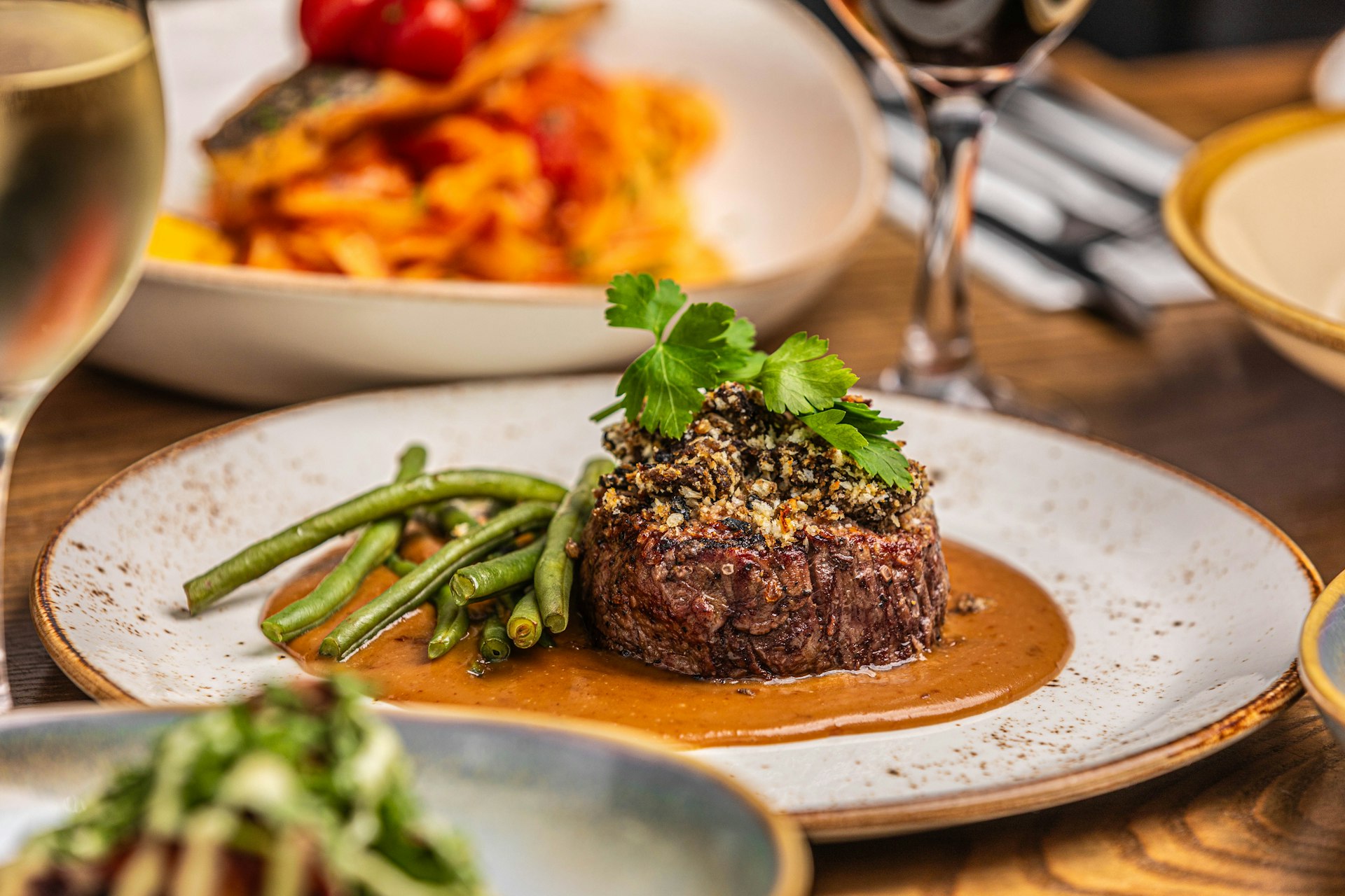 a plate of food on a table with a glass of wine